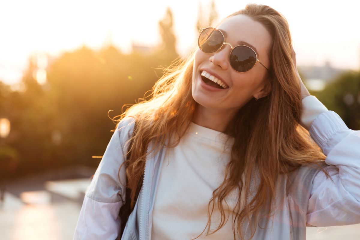 Woman wearing Sunglasses with a sunset in the background